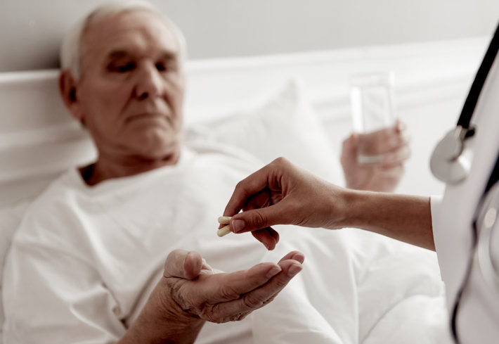 Senior being given pills