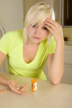 Young woman taking prescription drugs.