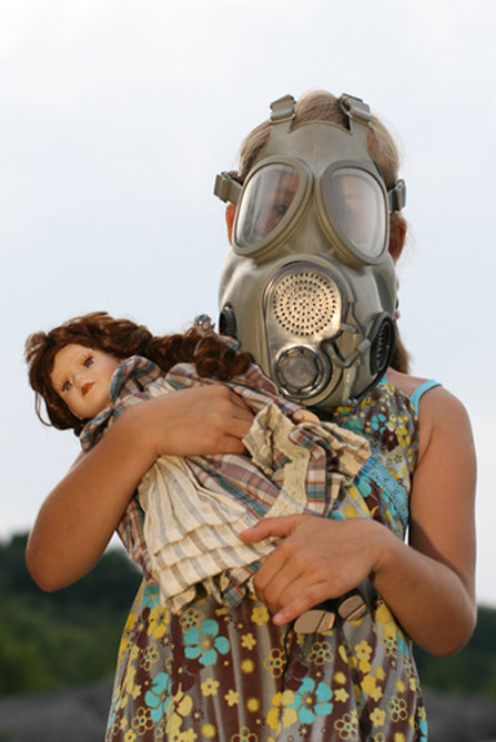 Little girl with a gas mask and a doll