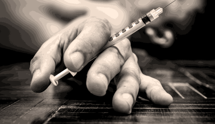 Hand holds an empty syringe