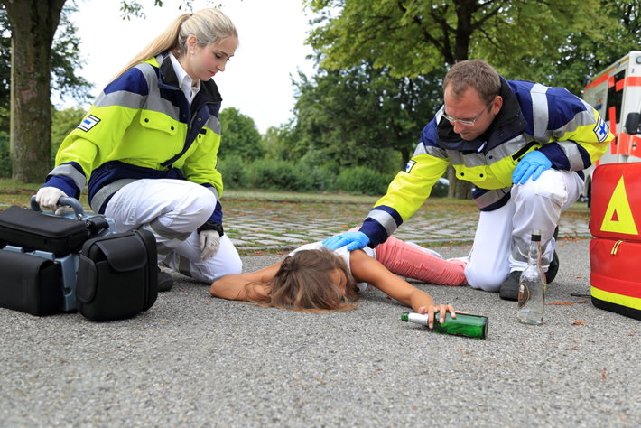 Paramedics helping a drunk woman who poisoned on tainted alcohol.