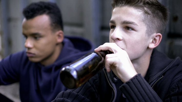 Young teenage boy drinking alcohol.