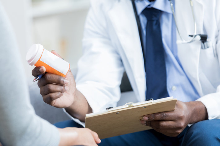 American doctor hands a prescription medication bottle