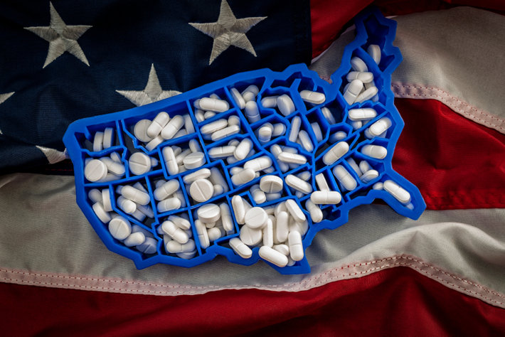 America shaped pills container on USA flag.