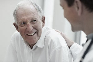 Happy old man having a casual talk with a doctor